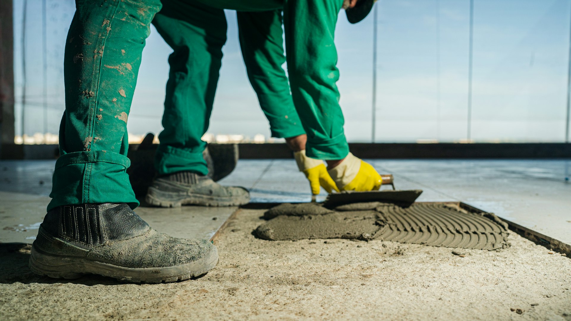 A person in green pants and yellow shoes